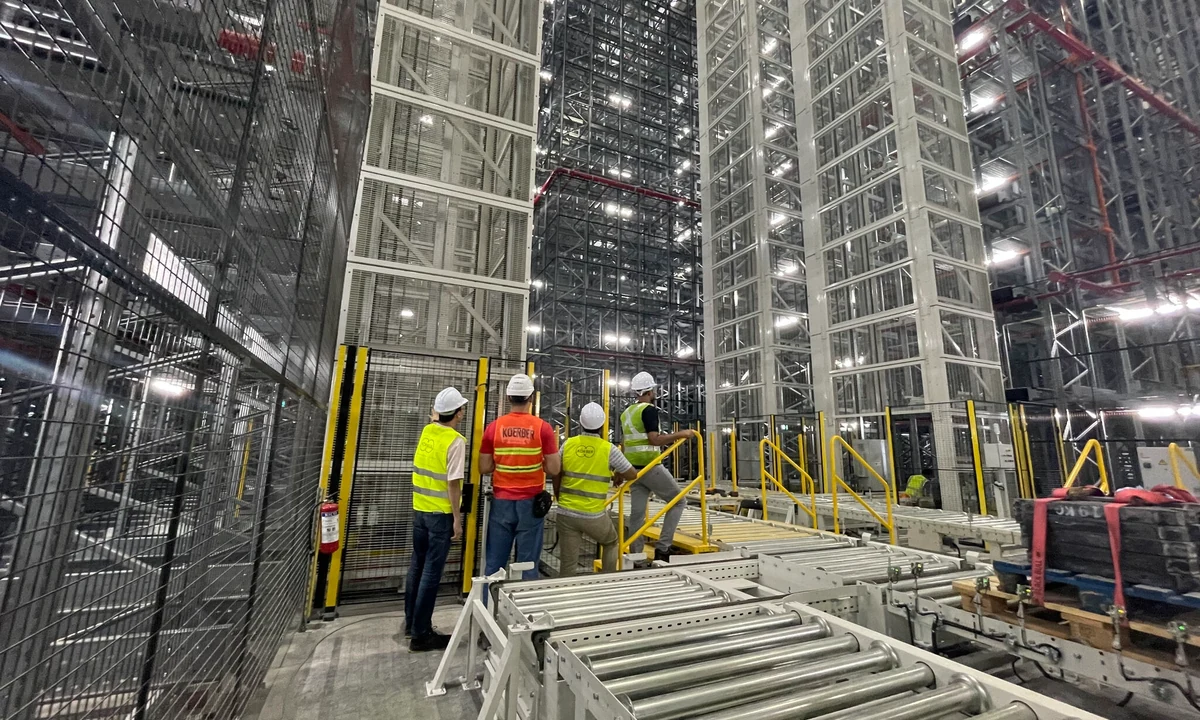 Workers inspect conveyors and storage racks inside the automated warehouse completed by Körber in Southeast Asia.