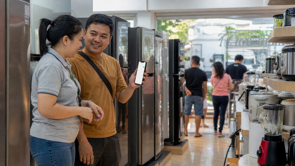 A customer and store employee discussing an appliance purchase in a Philippine retail shop